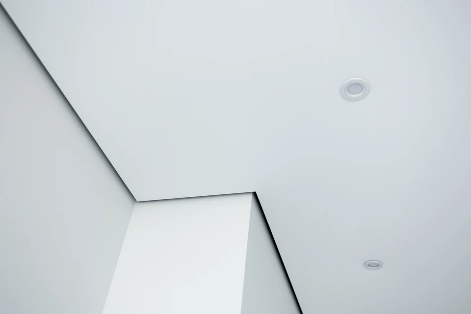 Scène intérieure moderne avec plafond suspendu blanc comportant panneaux modulaires assemblés