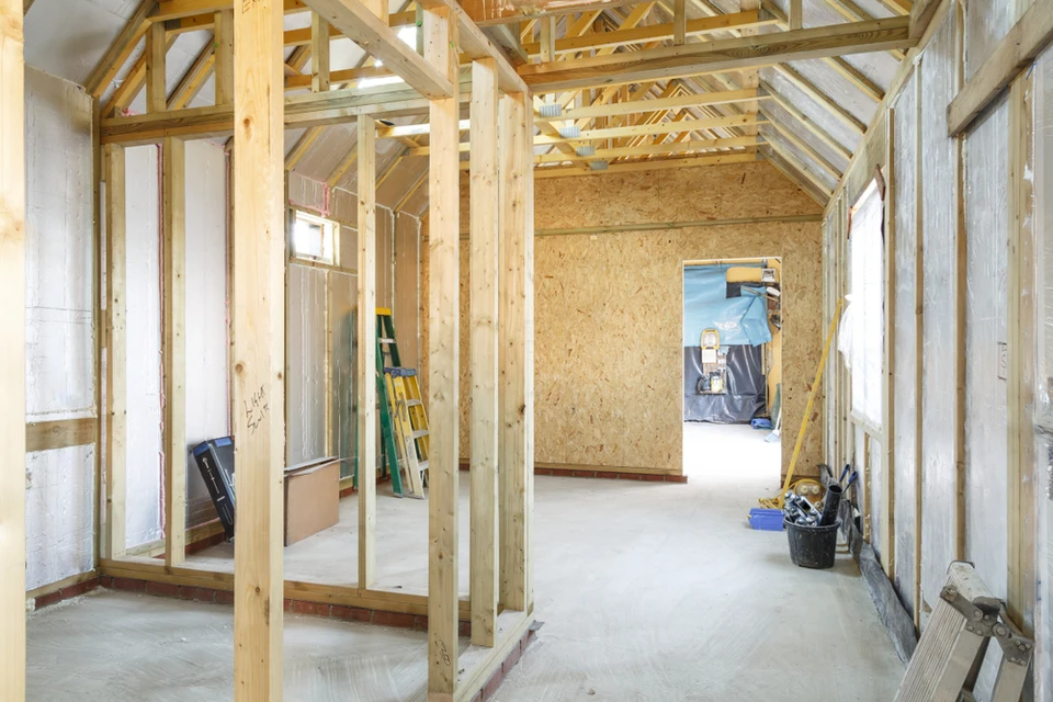 Intérieur de maison en construction avec charpente bois apparente